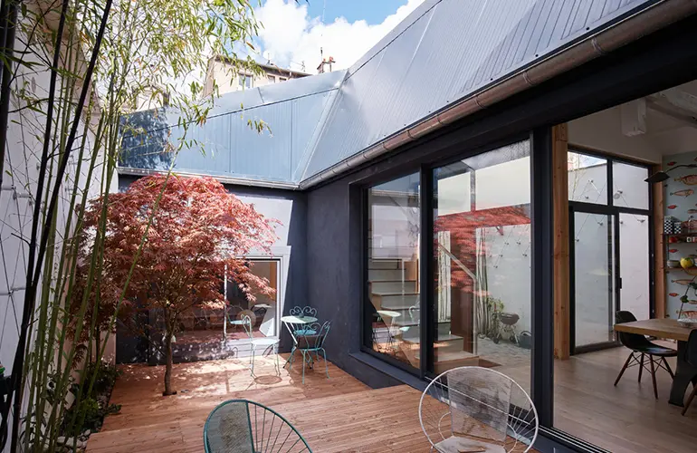 Réaménagement d'un garage en loft par Lisandre : Création d'un patio avec jardin