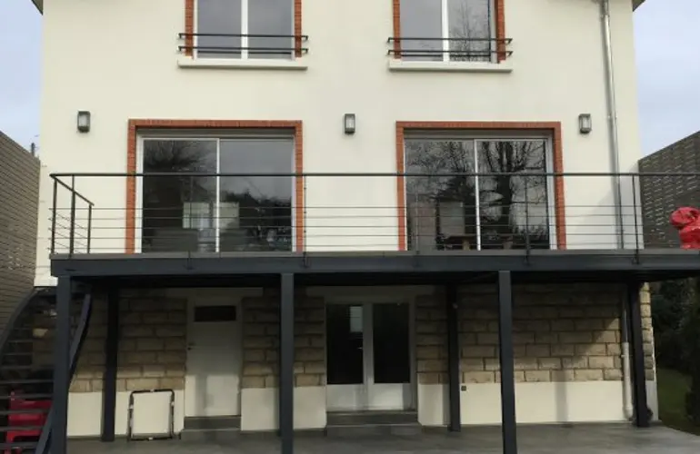 Rénovation extérieure par Lisandre de cette maison en banlieue Sud de Paris et aménagement d'une terrasse sur pilotis.