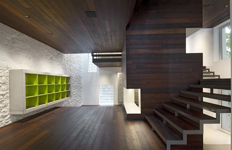 Maison escalier à Paris : Le choix des matériaux a été soigneusement étudié pour créer un contraste saisissant avec la blancheur des murs avoisinants